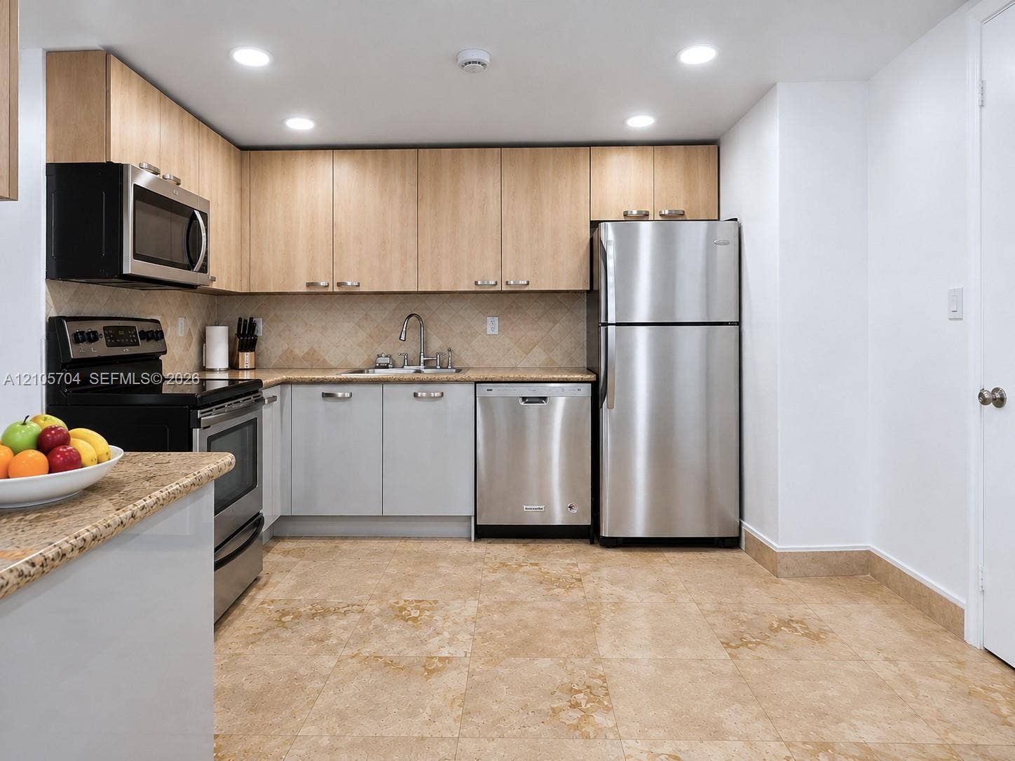 251 174th Street, #212, Sunny Isles Beach, Sunny Isles Beach, FL 33160 Kitchen featuring two-tone cabinetry, stainless steel appliances, speckled stone-finish countertops, tiled backsplash, and stone-finish flooring