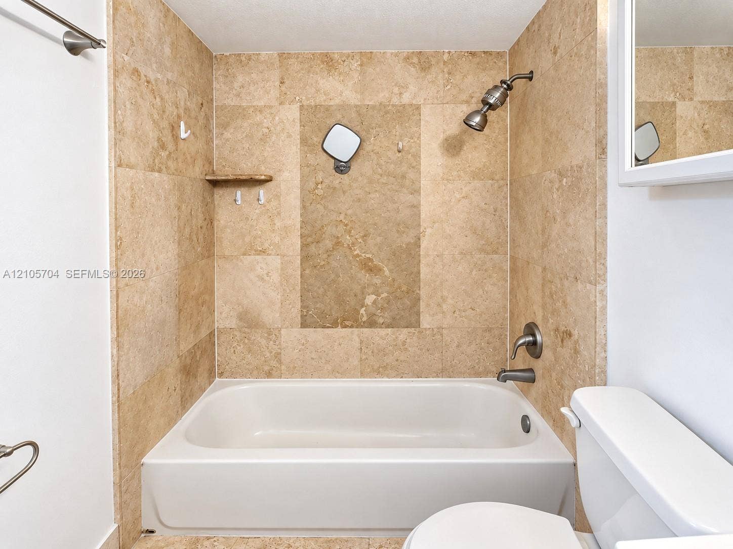 251 174th Street, #212, Sunny Isles Beach, Sunny Isles Beach, FL 33160 Kitchen featuring light wood-finish upper cabinetry, lower gray cabinetry, stone-tile flooring, stainless steel appliances, and a tiled backsplash