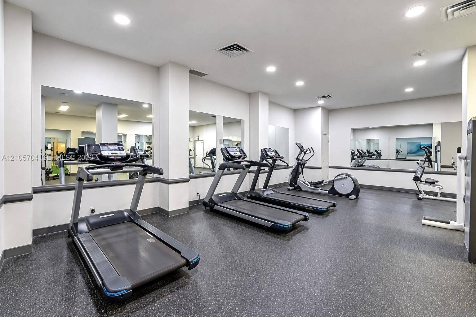 251 174th Street, #212, Sunny Isles Beach, Sunny Isles Beach, FL 33160 Fitness center featuring wall-to-wall mirrors, recessed lighting, and durable rubber flooring