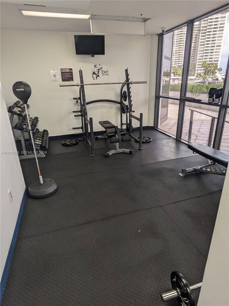 300 Three Islands Boulevard, #516, Hallandale Beach, FL 33009 Fitness area featuring rubberized flooring, floor-to-ceiling glass panels, and built-in weight training equipment