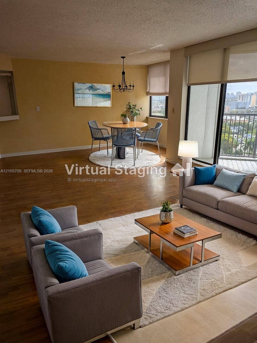 300 Three Islands Boulevard, #516, Hallandale Beach, FL 33009 Open living area featuring wood-finish flooring, floor-to-ceiling glass sliding doors, a private balcony, and an overhead chandelier fixture