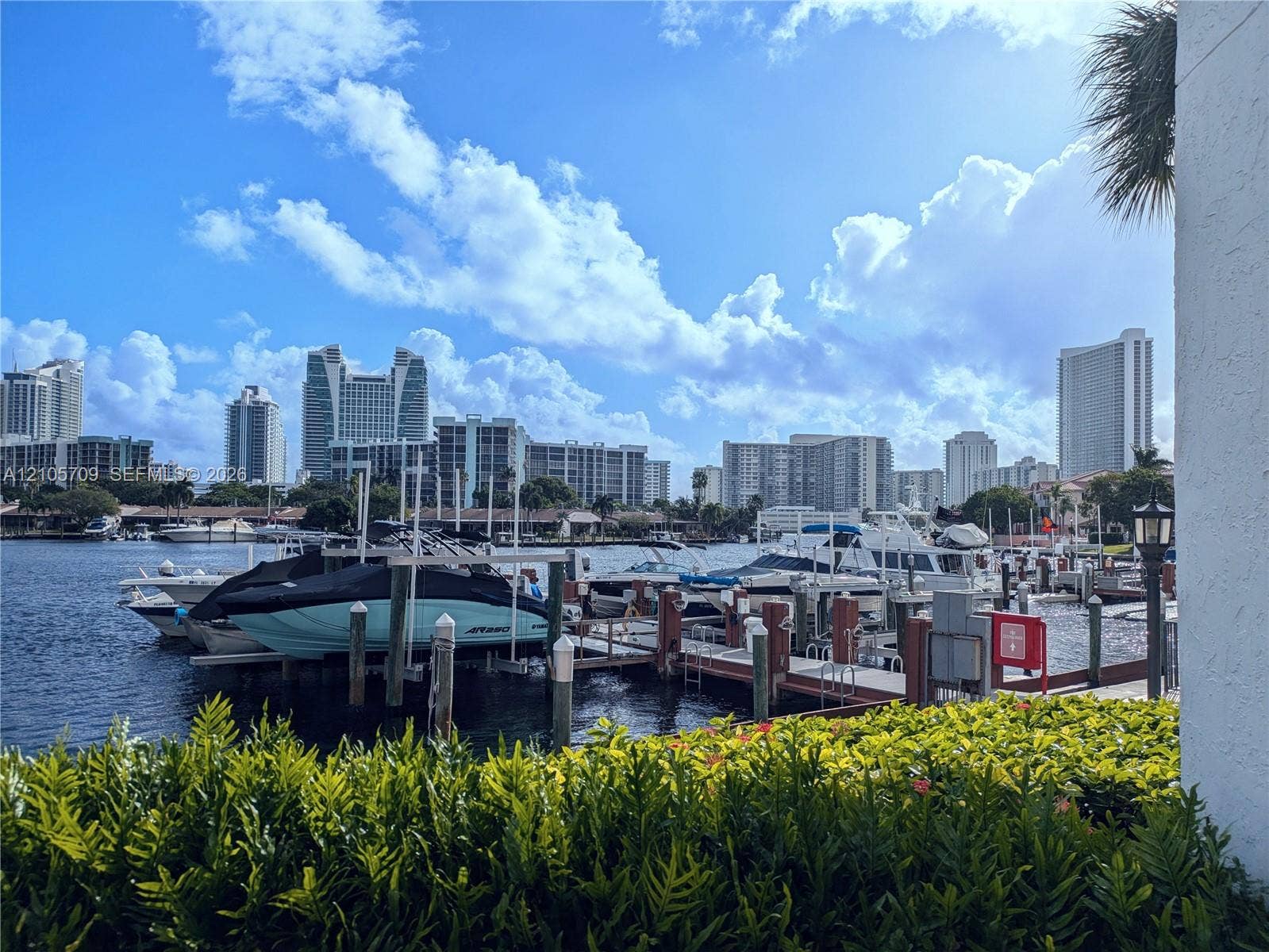 300 Three Islands Boulevard, #516, Hallandale Beach, FL 33009 Waterfront property featuring a private deep-water dock, integrated piling system, manicured landscaping, and bulkhead retaining wall