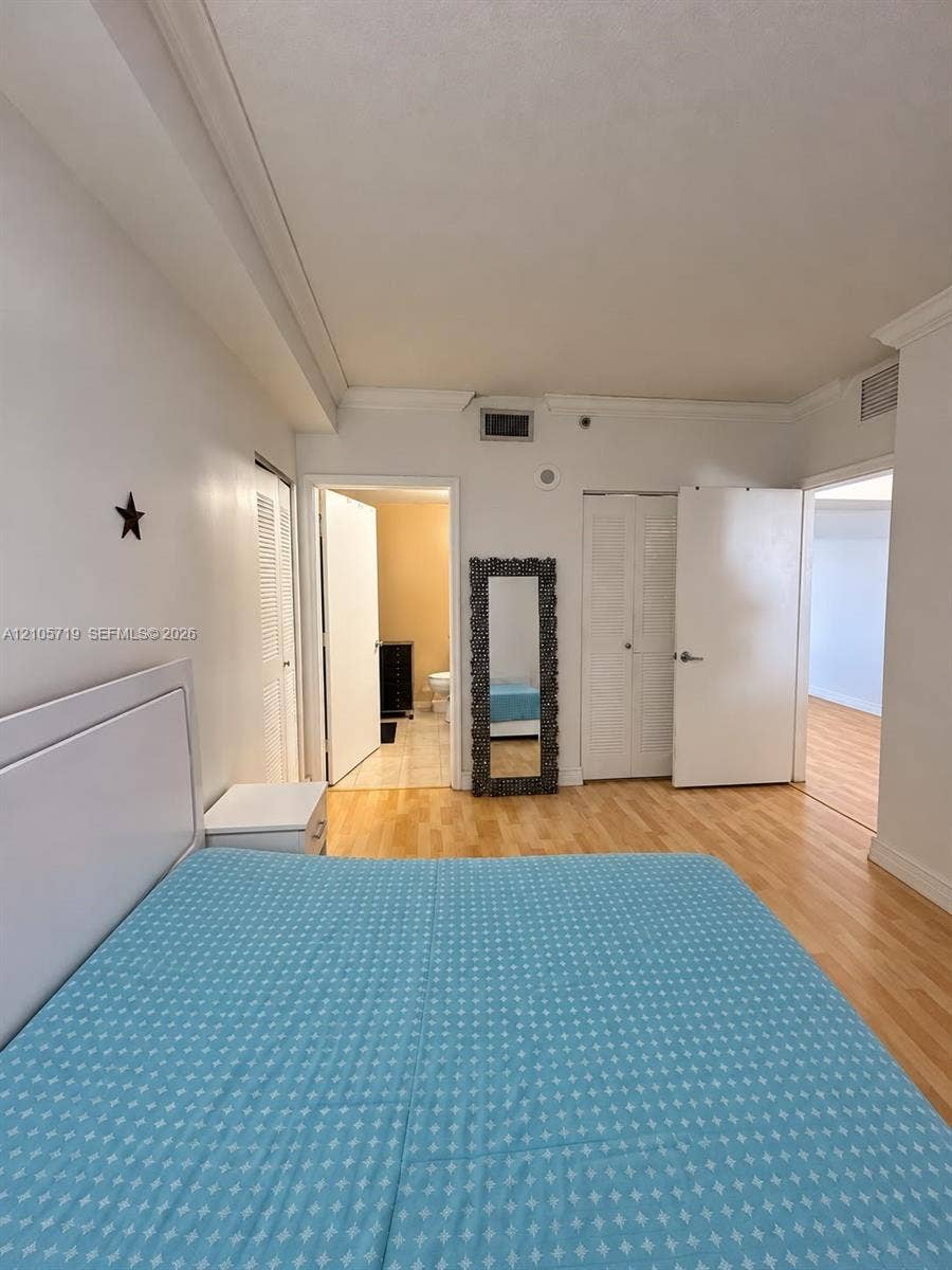 1 Glen Royal Parkway, #1510, Miami, FL 33125 Room featuring wood-finish flooring, crown molding, and double-door closets