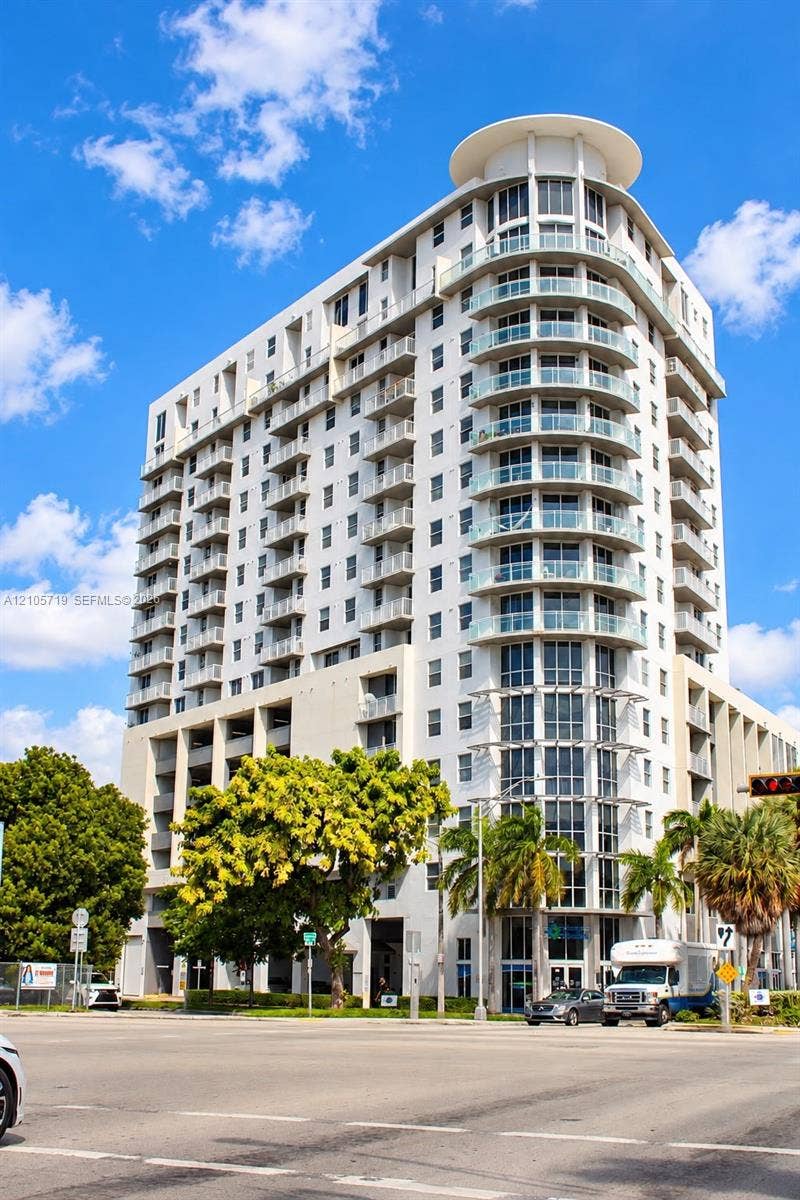 1 Glen Royal Parkway, #1510, Miami, FL 33125 High-rise exterior featuring curved glass balconies, concrete facade, and a tiered architectural roofline