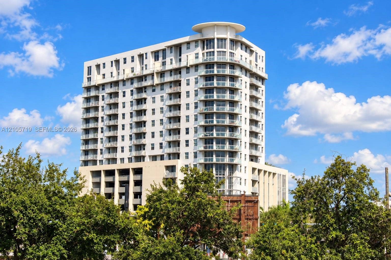 1 Glen Royal Parkway, #1510, Miami, FL 33125 Modern residential tower featuring curved architectural lines, extensive glazing across multiple stories, and a rounded corner design