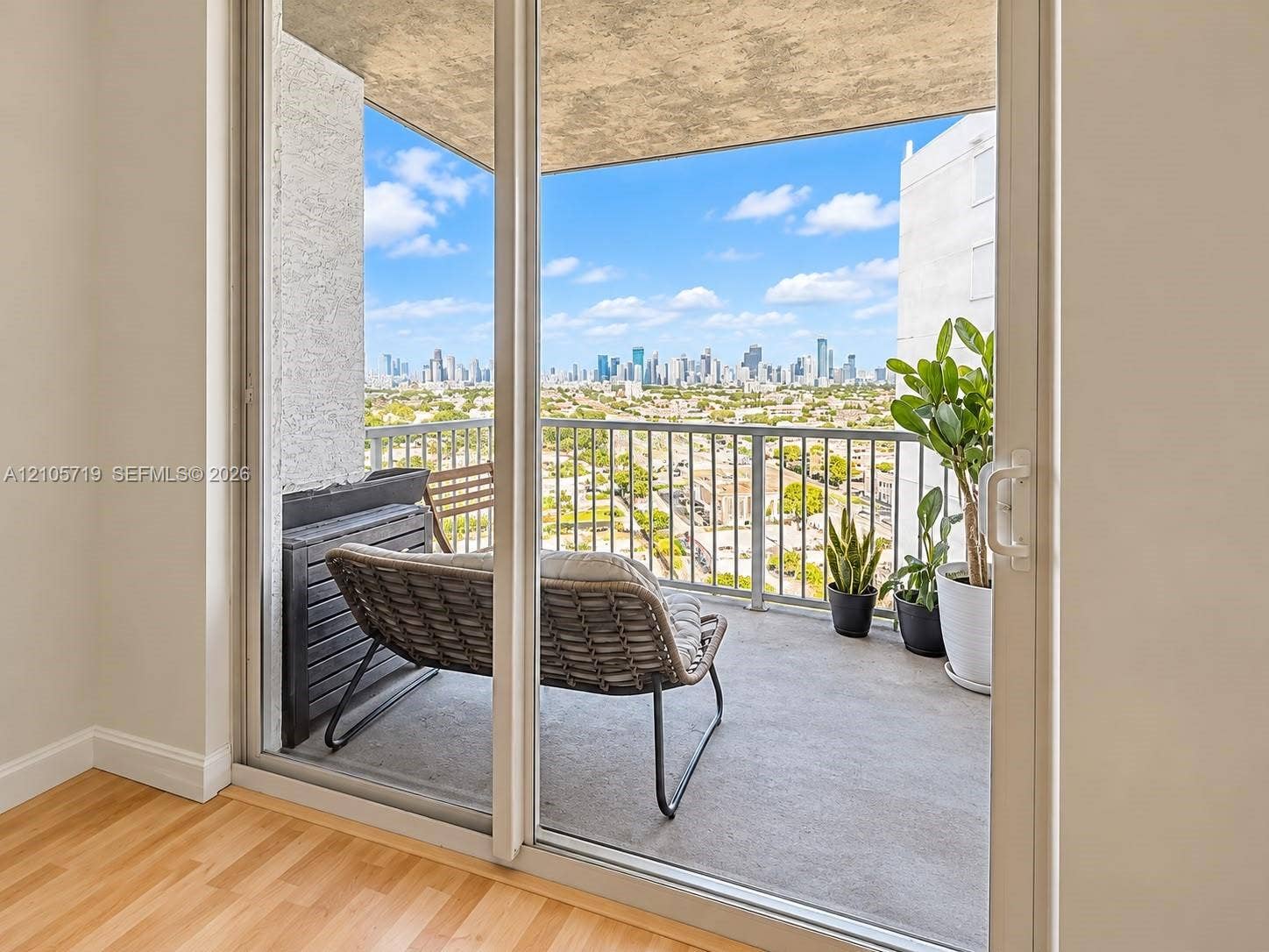 1 Glen Royal Parkway, #1510, Miami, FL 33125 Private balcony featuring concrete flooring, a metal railing, and a cityscape backdrop, accessible through glass sliding doors