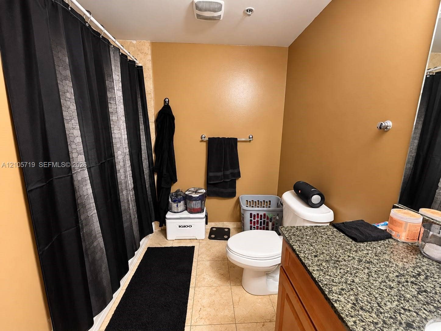 1 Glen Royal Parkway, #1510, Miami, FL 33125 Bathroom featuring a vanity with a stone-finish countertop, neutral tile flooring, and a tub enclosure