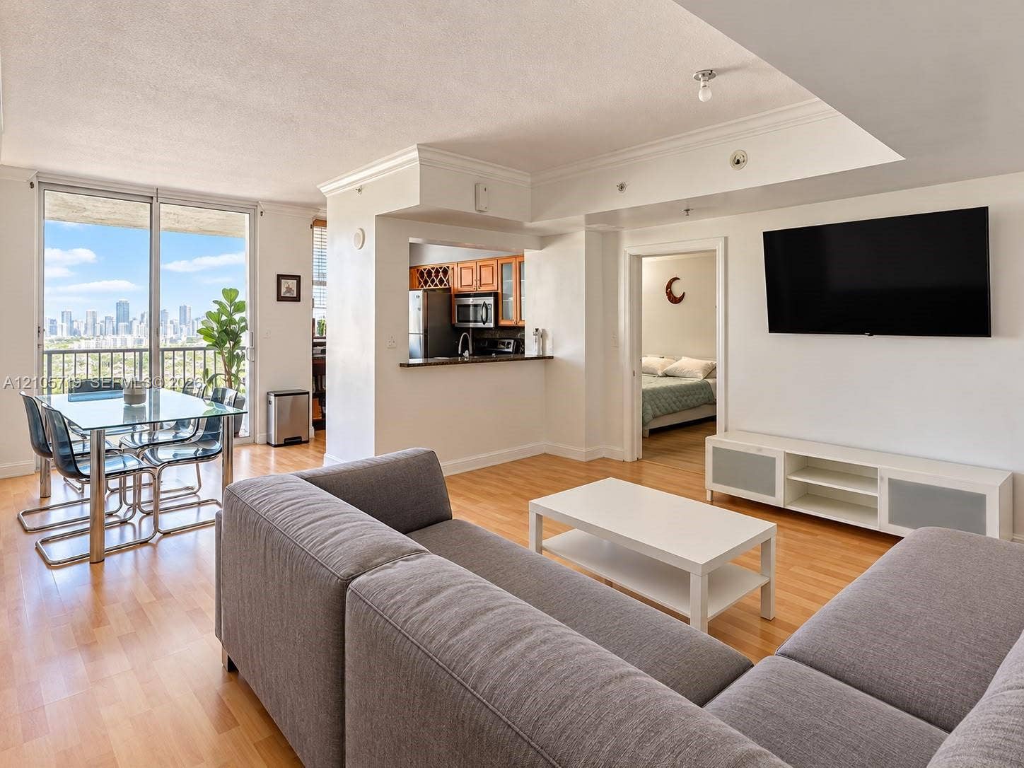 1 Glen Royal Parkway, #1510, Miami, FL 33125 Open-concept floor plan featuring wood-finish flooring, floor-to-ceiling glass sliding doors, built-in cabinetry, and crown molding