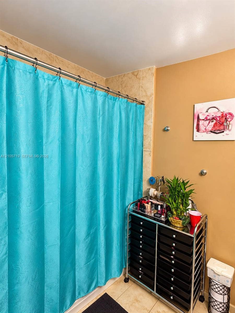 1 Glen Royal Parkway, #1510, Miami, FL 33125 Stone-finish tile shower surround with a metal curtain rod and neutral wall tones