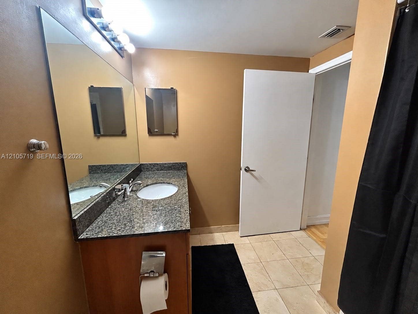 1 Glen Royal Parkway, #1510, Miami, FL 33125 Vanity featuring stone-style countertop, oval undermount sink, large wall-mounted mirror, and tile flooring