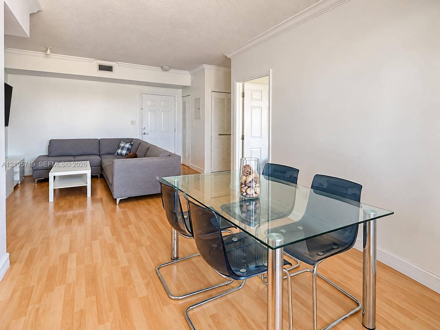 1 Glen Royal Parkway, #1510, Miami, FL 33125 Interior space featuring wood-finish flooring, crown molding, six-panel interior doors, and a neutral color palette