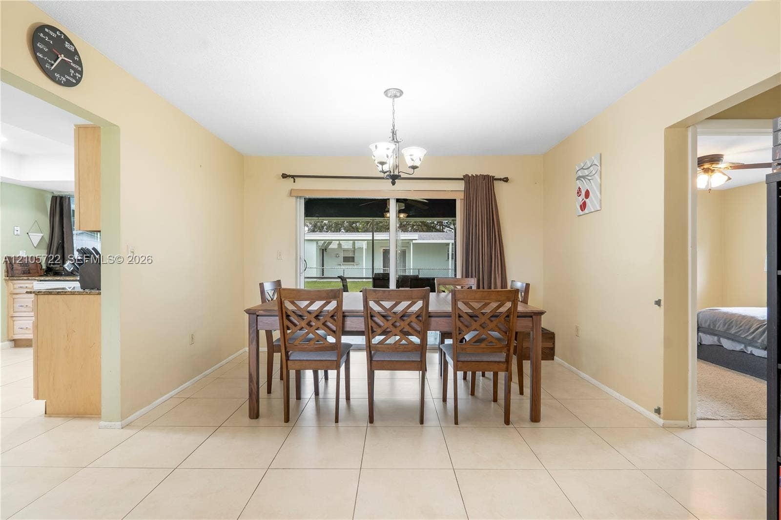 8953 SW 53rd Street, Cooper City, FL 33328 Dining area featuring large-format ceramic tile flooring, a multi-light chandelier, and sliding glass doors providing outdoor access