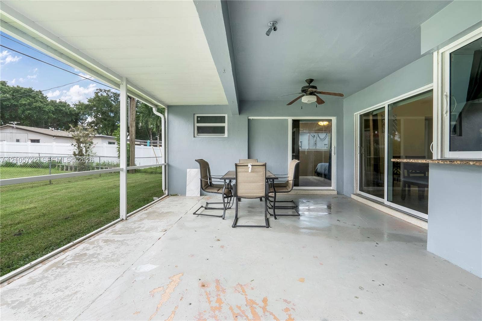 8953 SW 53rd Street, Cooper City, FL 33328 Screened-in patio featuring a concrete floor, ceiling fan, and sliding glass door entry