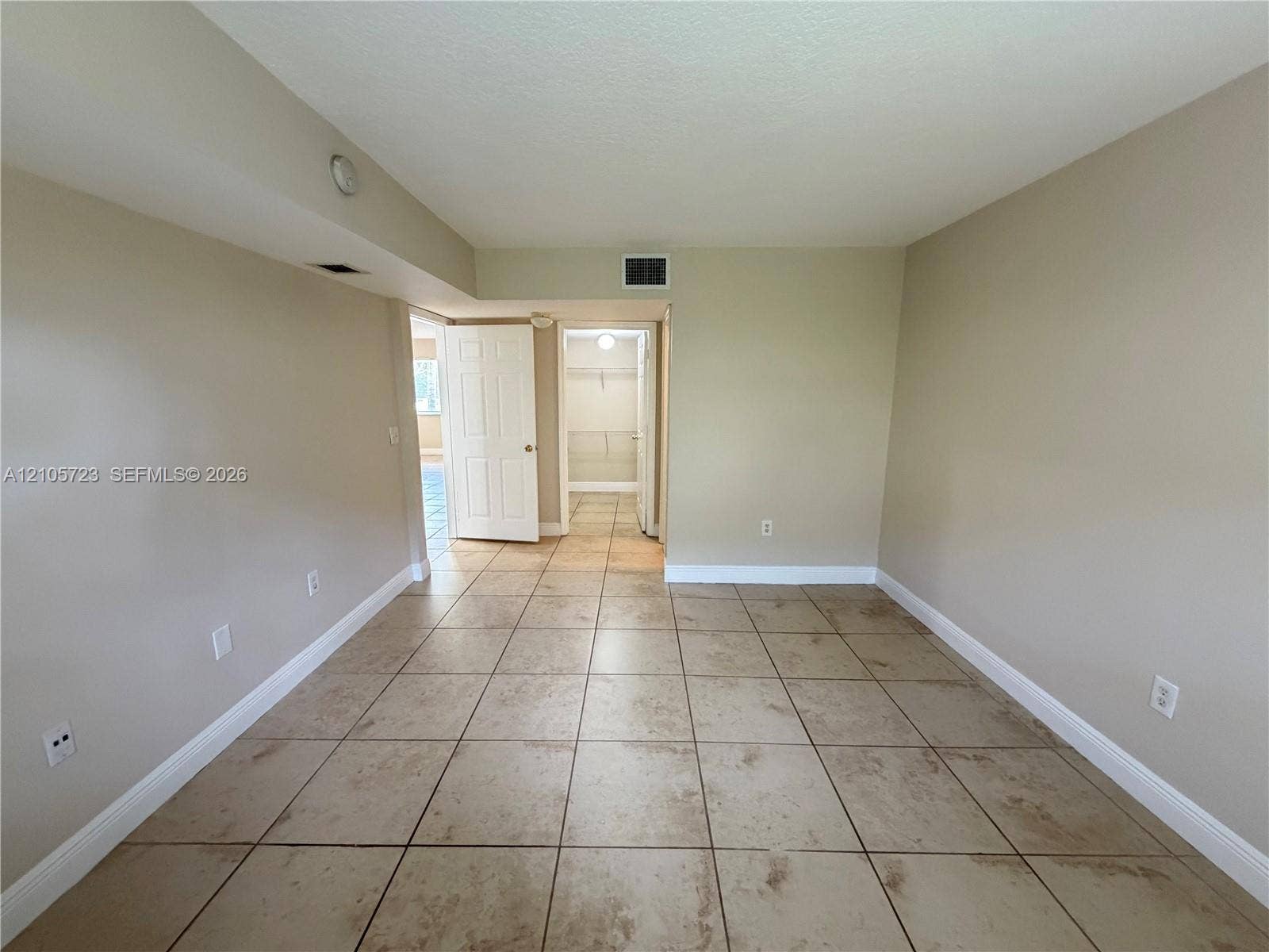 4785 SW 62nd Avenue, #102, Davie, Davie, FL 33314 Neutral-toned interior space featuring tile flooring and a walk-in closet with built-in shelving
