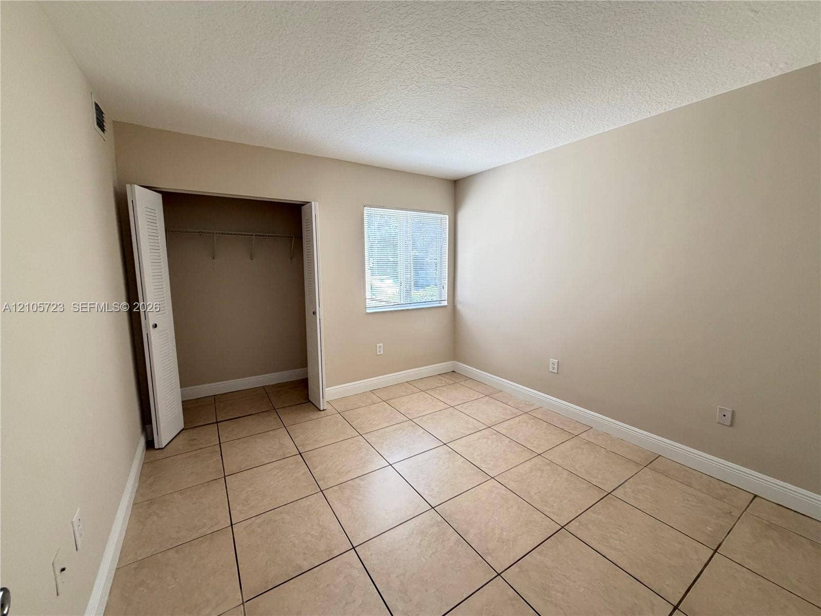 4785 SW 62nd Avenue, #102, Davie, Davie, FL 33314 Neutral wall tones, large-format tile flooring, single window, and a built-in closet with louvered doors