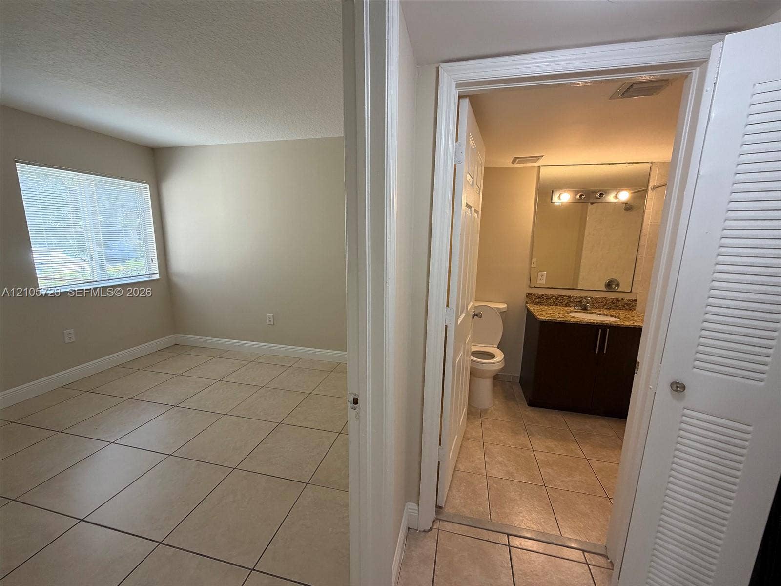 4785 SW 62nd Avenue, #102, Davie, Davie, FL 33314 Room featuring neutral wall tones and tile flooring throughout, accompanied by a bathroom vanity with a countertop, integrated sink, and wall-mounted mirror
