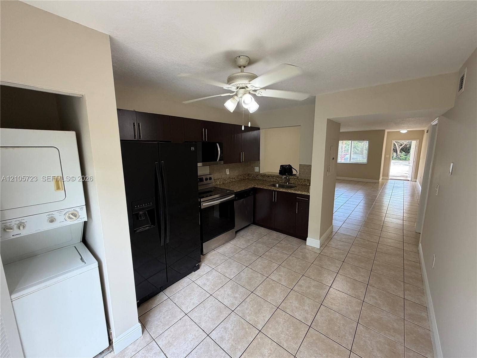 4785 SW 62nd Avenue, #102, Davie, Davie, FL 33314 Kitchen featuring dark cabinetry, stone-finish countertops, stainless steel appliances, tile flooring, and ceiling fan with integrated lighting