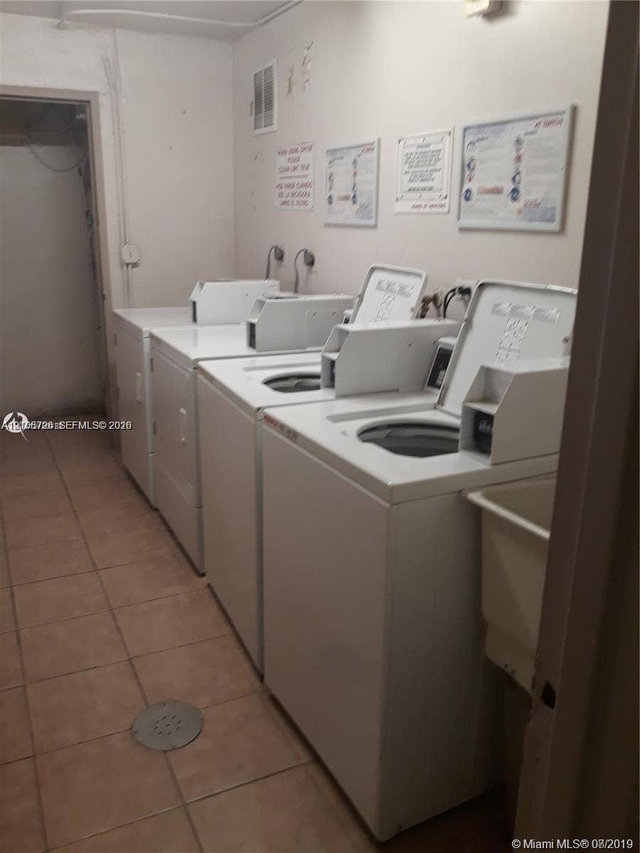 200 172nd Street, #101, Sunny Isles Beach, FL 33160 Laundry area featuring multiple top-loading washing machines and ceramic tile flooring