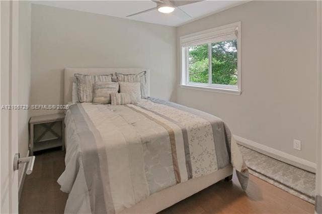 Neutral-toned room featuring wood-finish flooring, a ceiling fan with integrated lighting, and a horizontal sliding window
