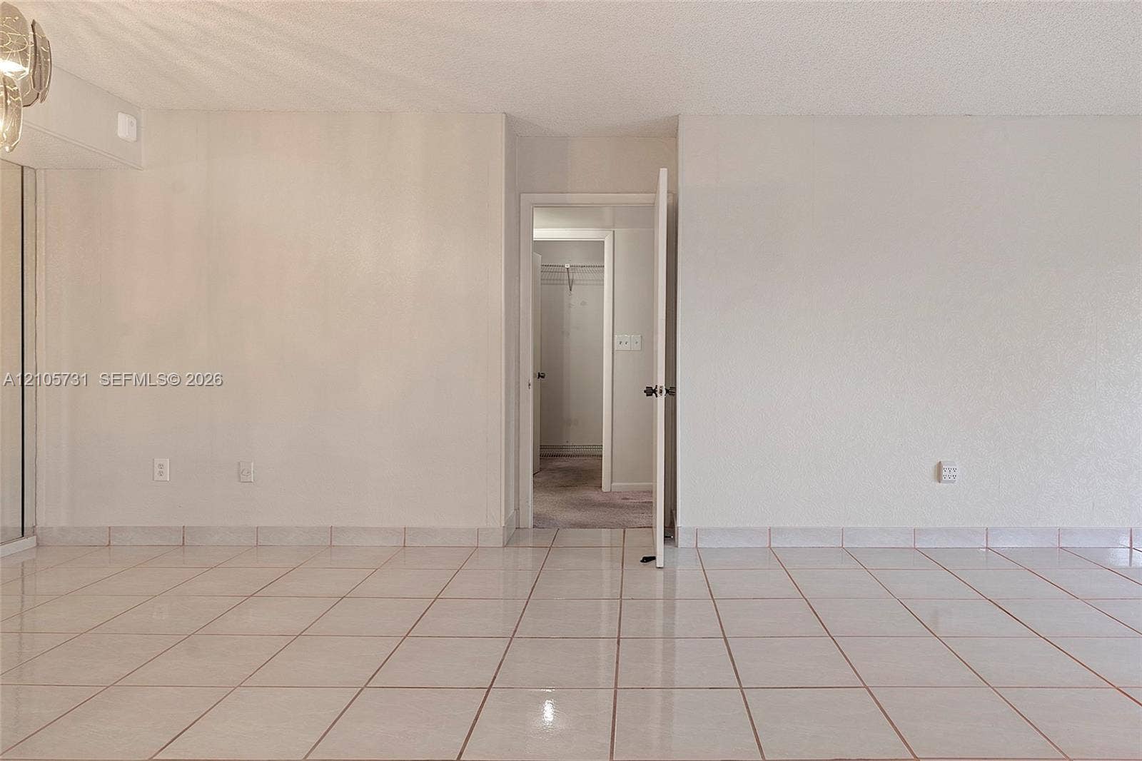 5700 SW 127th Avenue, #1404, Miami, FL 33183 Neutral ceramic tile flooring and interior swing door leading to a walk-in closet with built-in shelving