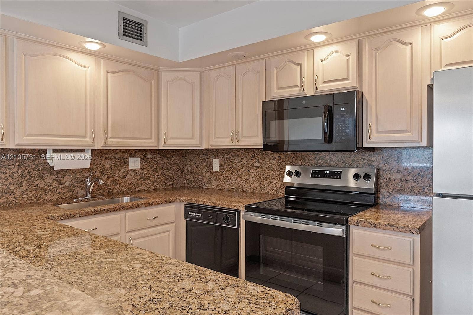 5700 SW 127th Avenue, #1404, Miami, FL 33183 Kitchen featuring neutral-toned cabinetry, stone countertops, stone backsplash, stainless steel appliances, and recessed lighting