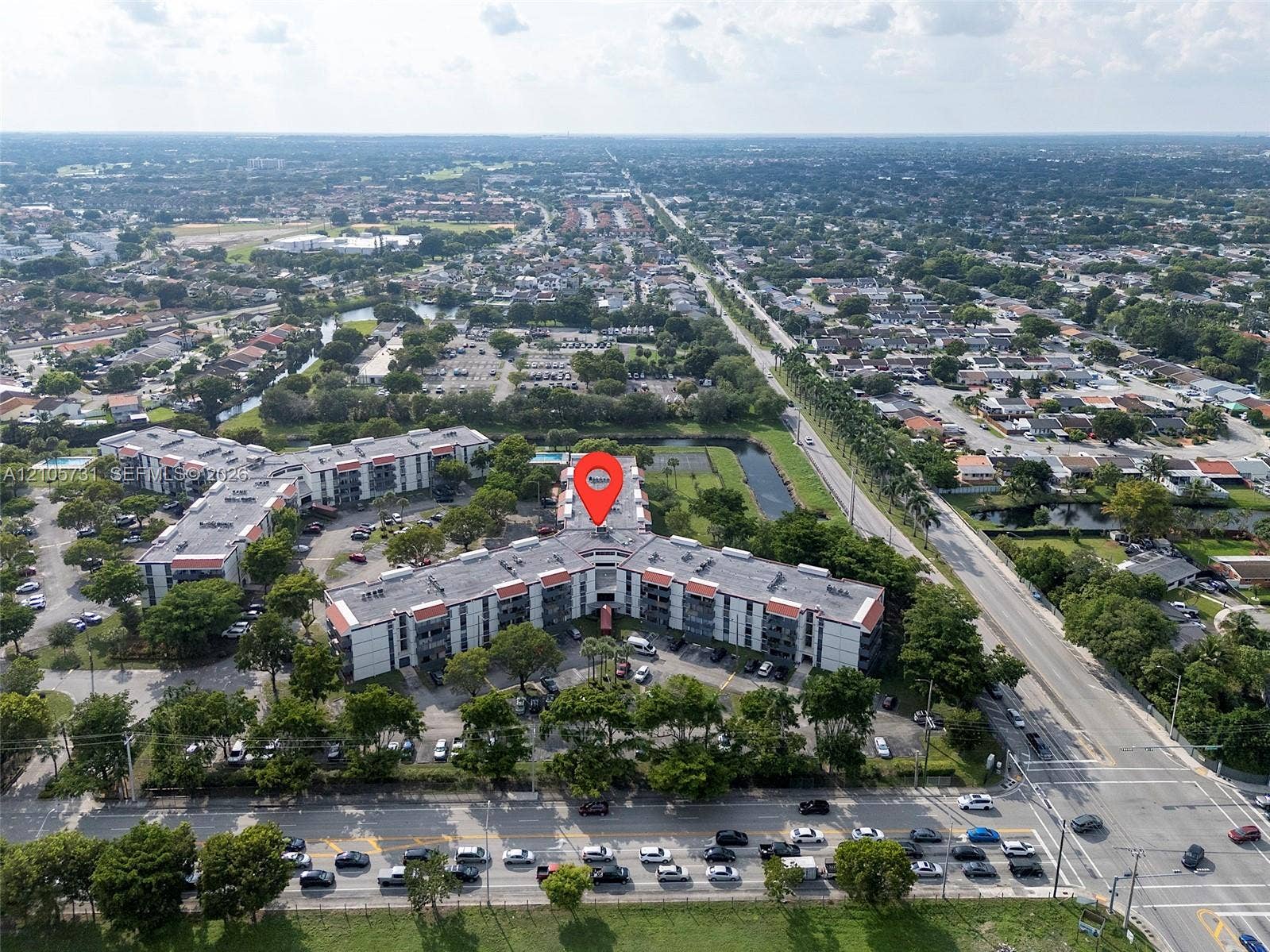 5700 SW 127th Avenue, #1404, Miami, FL 33183 Aerial view of a modern multi-unit residential complex featuring a distinctive curved architectural design with white exterior facades