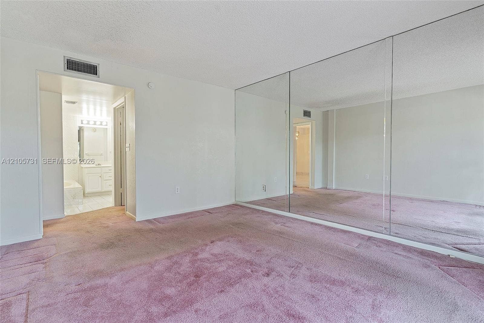 5700 SW 127th Avenue, #1404, Miami, FL 33183 Room featuring wall-to-wall mirrored closet doors and neutral wall finishes