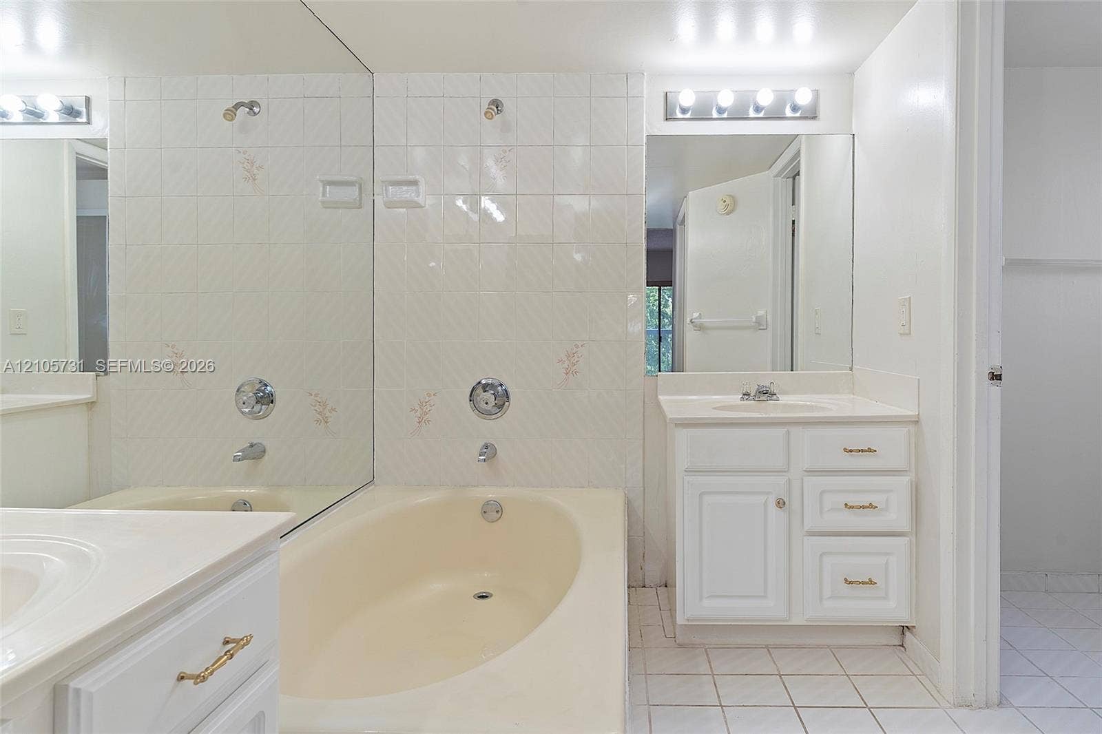 5700 SW 127th Avenue, #1404, Miami, FL 33183 Bathroom featuring a vanity with integrated sink, porcelain tile flooring, full-width wall mirror, and a bathtub with tiled surround