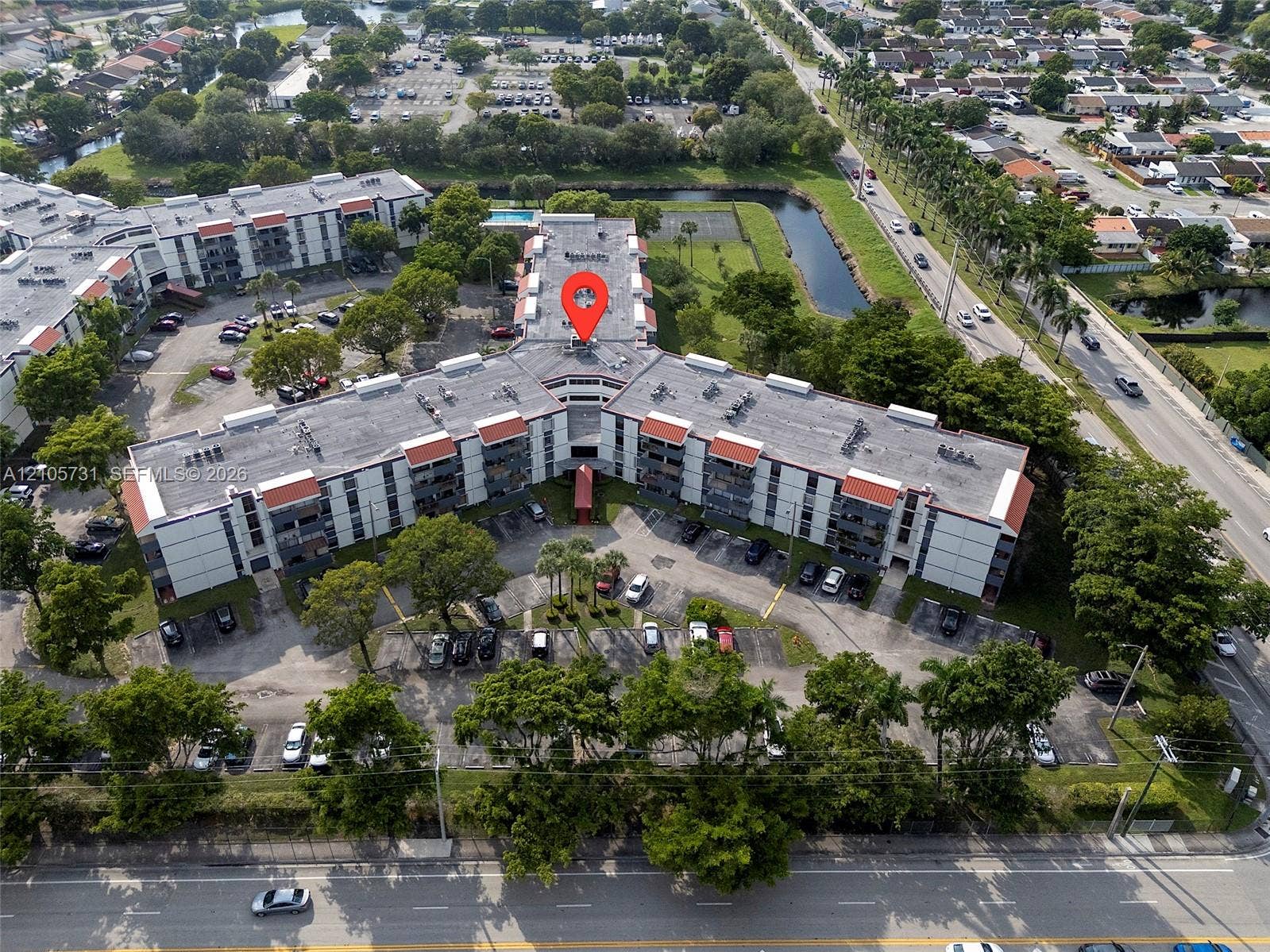 5700 SW 127th Avenue, #1404, Miami, FL 33183 Aerial view of the multi-story complex featuring surface-level parking and mature landscaping