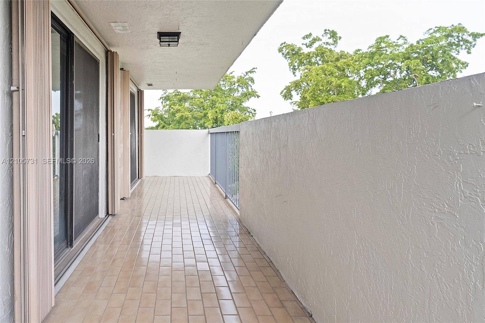 5700 SW 127th Avenue, #1404, Miami, FL 33183 Covered balcony featuring tile flooring, textured wall finishes, and metal railing