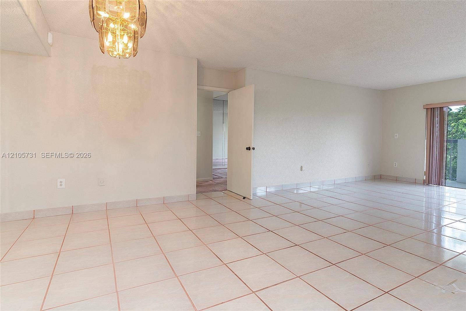 5700 SW 127th Avenue, #1404, Miami, FL 33183 Large format tile flooring, metallic multi-light chandelier, and full-height glass door panel