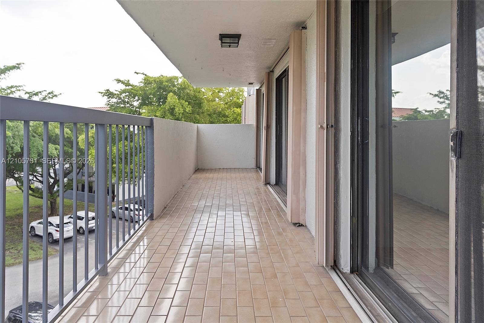 5700 SW 127th Avenue, #1404, Miami, FL 33183 Covered balcony featuring tile flooring, metal railing, and sliding glass door access