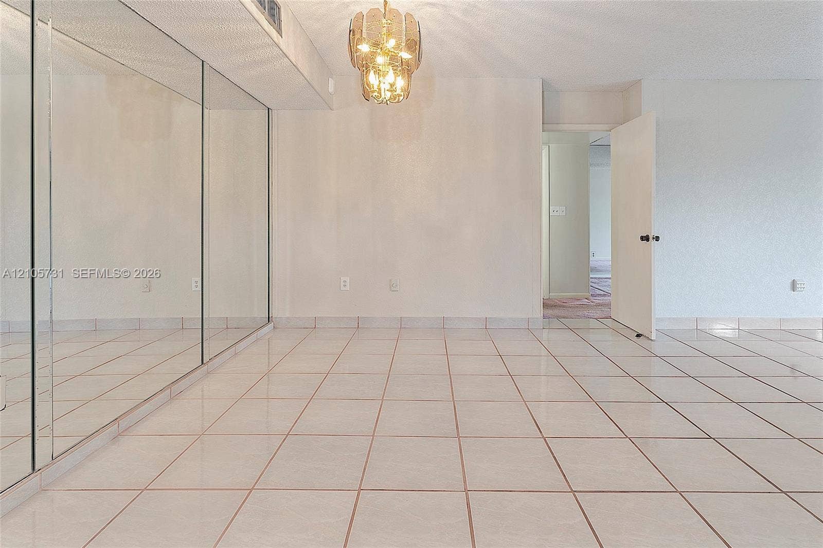 5700 SW 127th Avenue, #1404, Miami, FL 33183 Ceramic tile flooring, full-wall mirrors, and a decorative tiered chandelier