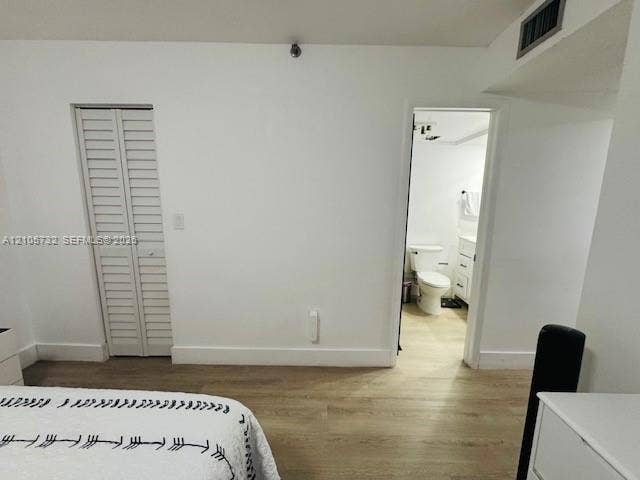 5249 NW 7th Street, #219, Miami, Miami, FL 33126 Room featuring wood-finish flooring, white walls, and a bi-fold closet door