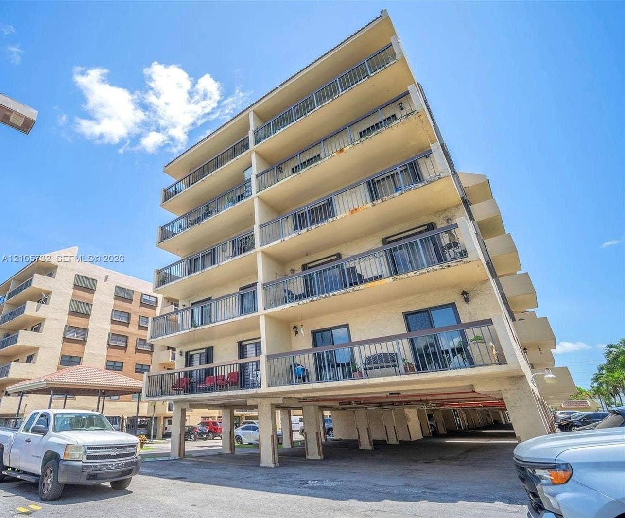 5249 NW 7th Street, #219, Miami, Miami, FL 33126 Multi-story residential building featuring five levels of private balconies with metal railings and ground-level covered parking