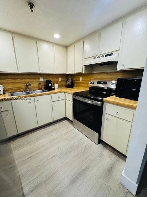 5249 NW 7th Street, #219, Miami, Miami, FL 33126 Kitchen featuring flat-panel cabinetry, wood-finish countertops, stainless steel range with overhead vent hood, dual-basin stainless steel sink, and light-toned wood-finish flooring