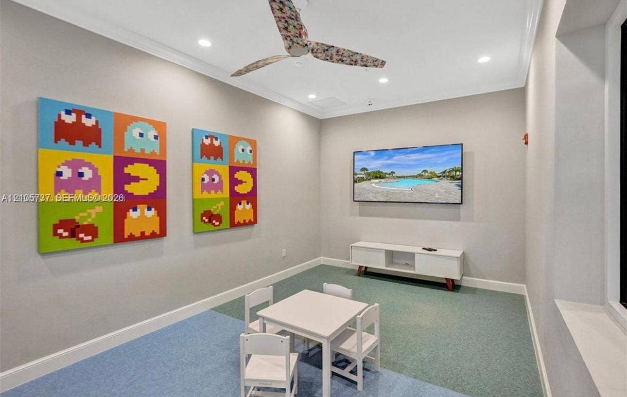 Neutral-toned interior featuring recessed lighting, a patterned ceiling fan, and carpeted flooring