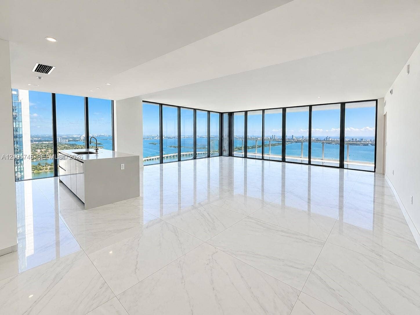 725 NE 24, #5401, Miami, Miami, FL 33137 Open-concept space featuring floor-to-ceiling windows, polished stone-finish tile flooring, and a kitchen island with a neutral countertop and integrated sink