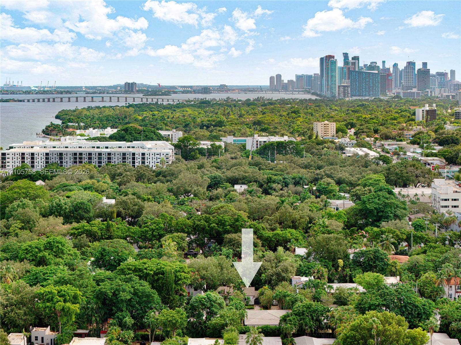 668 NE 70th Street, Miami, FL 33138 Aerial perspective featuring mature tree canopy and urban skyline backdrop
