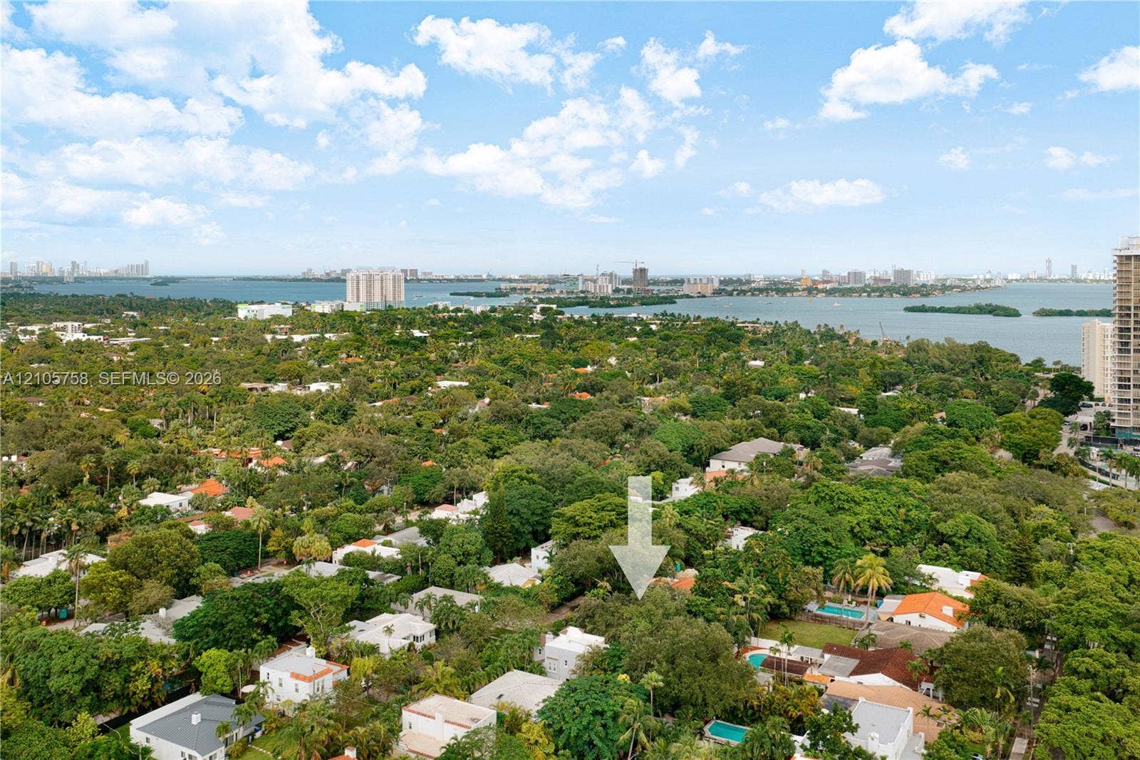 668 NE 70th Street, Miami, FL 33138 Aerial perspective highlighting a tree-lined residential setting with water access and coastal scenery