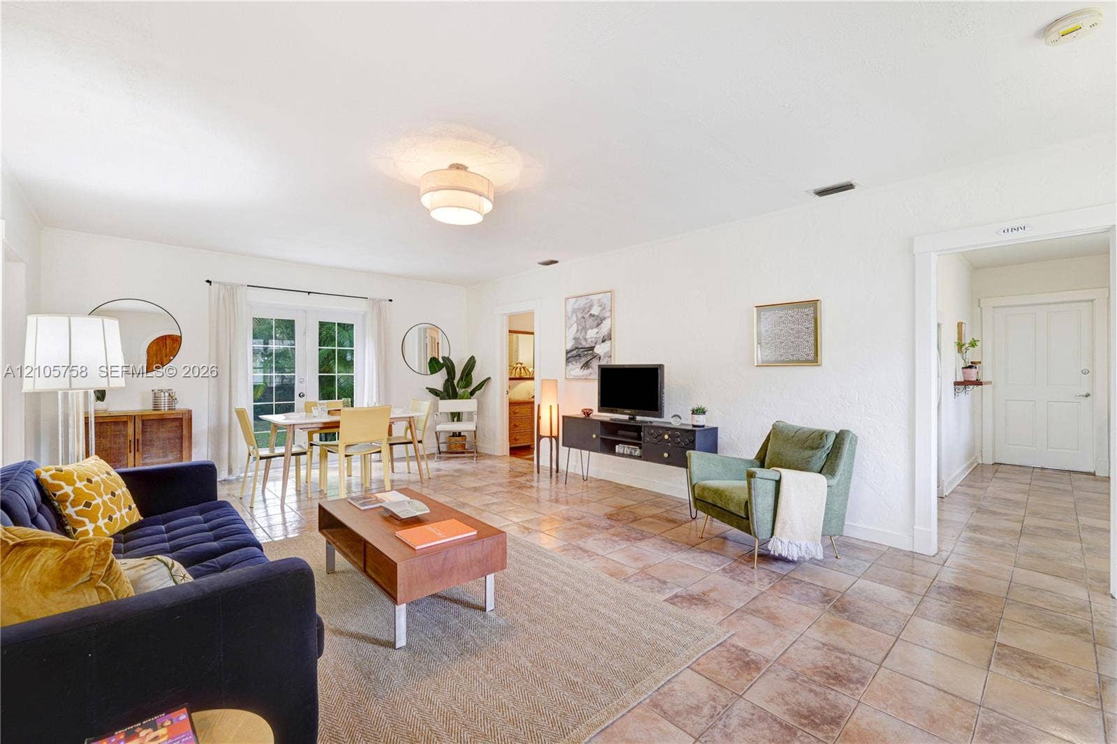 668 NE 70th Street, Miami, FL 33138 Living area featuring square tile flooring, semi-flush mount ceiling lighting, and glass-paneled double doors