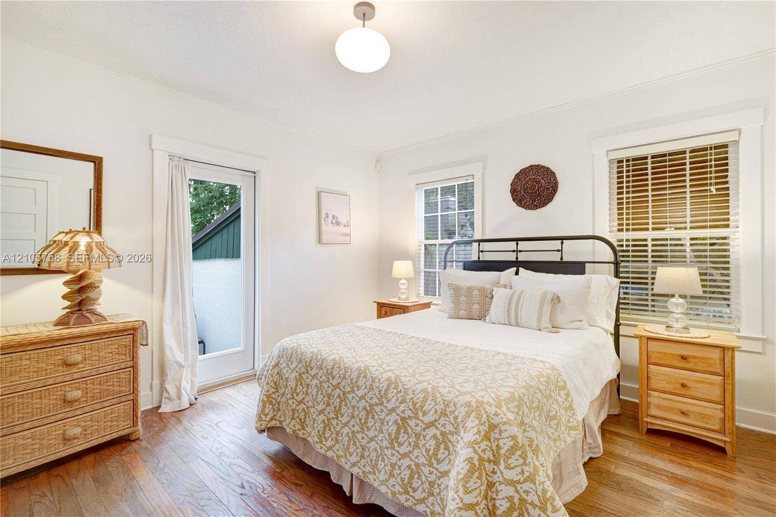 668 NE 70th Street, Miami, FL 33138 Wood-finish flooring, glass-paned door, multi-pane windows with horizontal blinds, and globe-style ceiling fixture