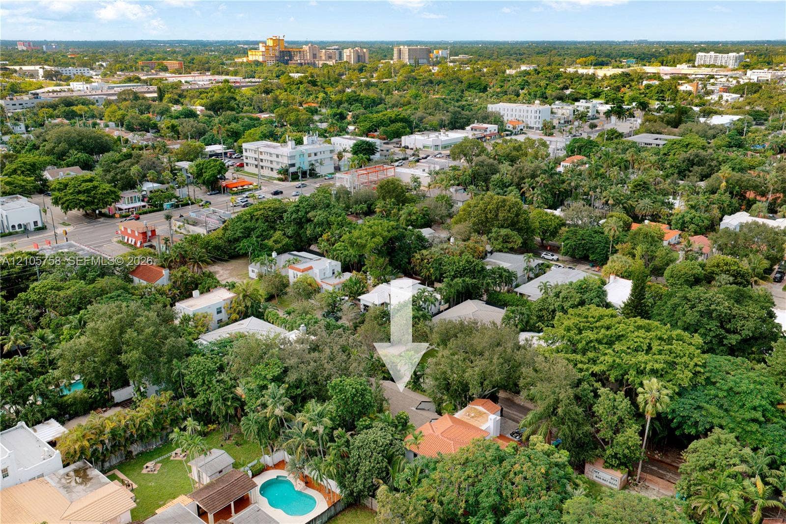 668 NE 70th Street, Miami, FL 33138 Aerial perspective of property featuring mature trees, a swimming pool, and a tile roof