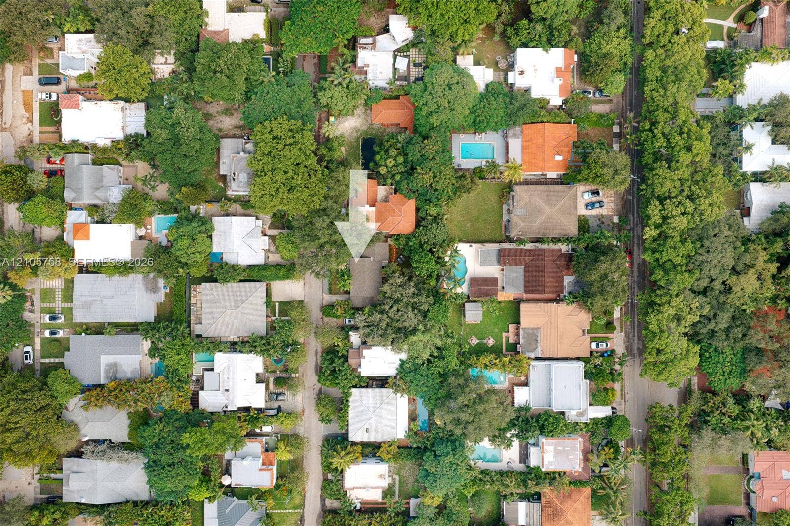 668 NE 70th Street, Miami, FL 33138 Aerial perspective showcasing a residential property with established tree canopy and mature landscaping