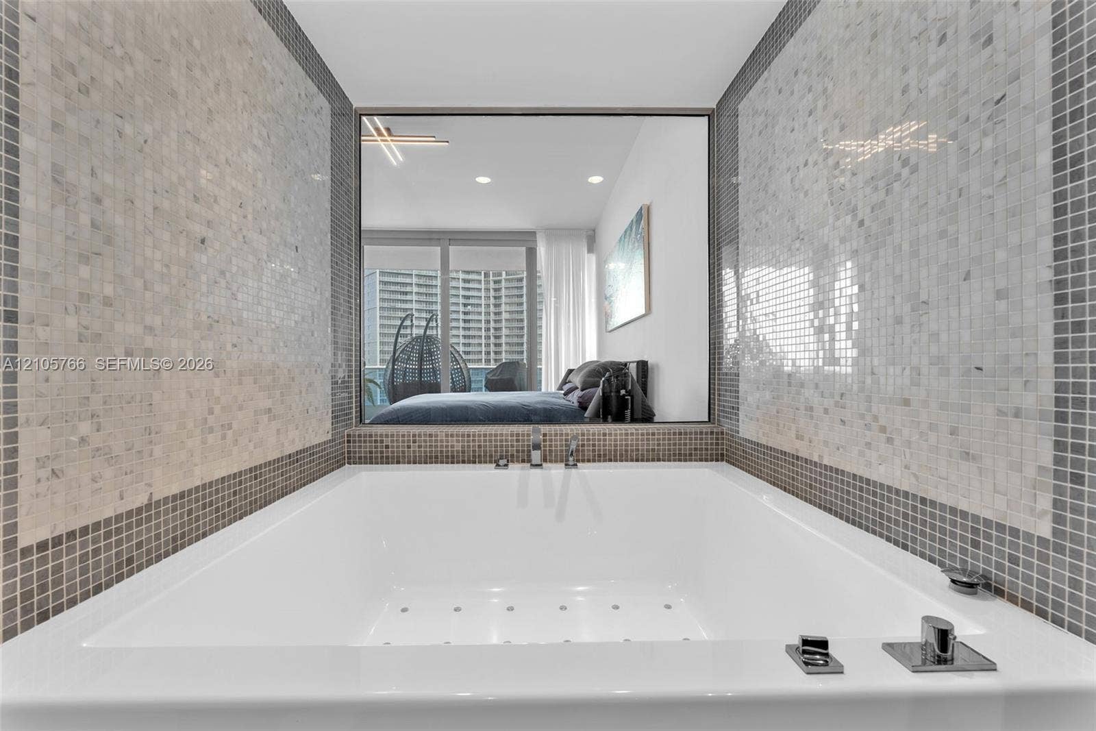200 Biscayne Boulevard Way, #4408, Miami, FL 33131 Jetted tub in the primary bath, with an interior glass window into the primary bedroom.