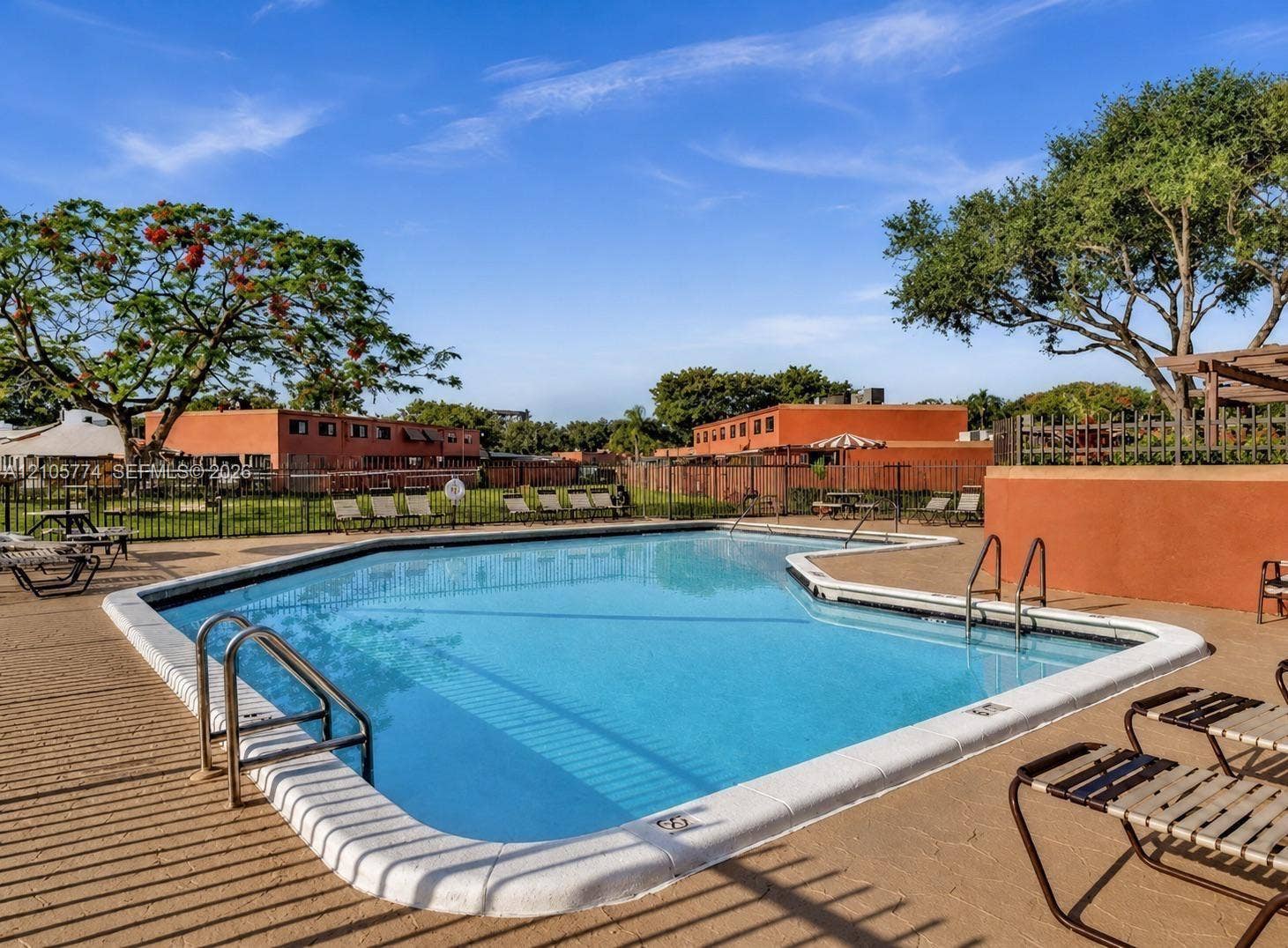 10343 Greenhouse Road, Pembroke Pines, FL 33026 Swimming pool featuring a concrete deck, metal railings, and perimeter fencing