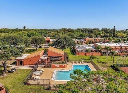 10343 Greenhouse Road, Pembroke Pines, FL 33026 Community swimming pool featuring a masonry surround, perimeter fencing, and an attached pergola structure