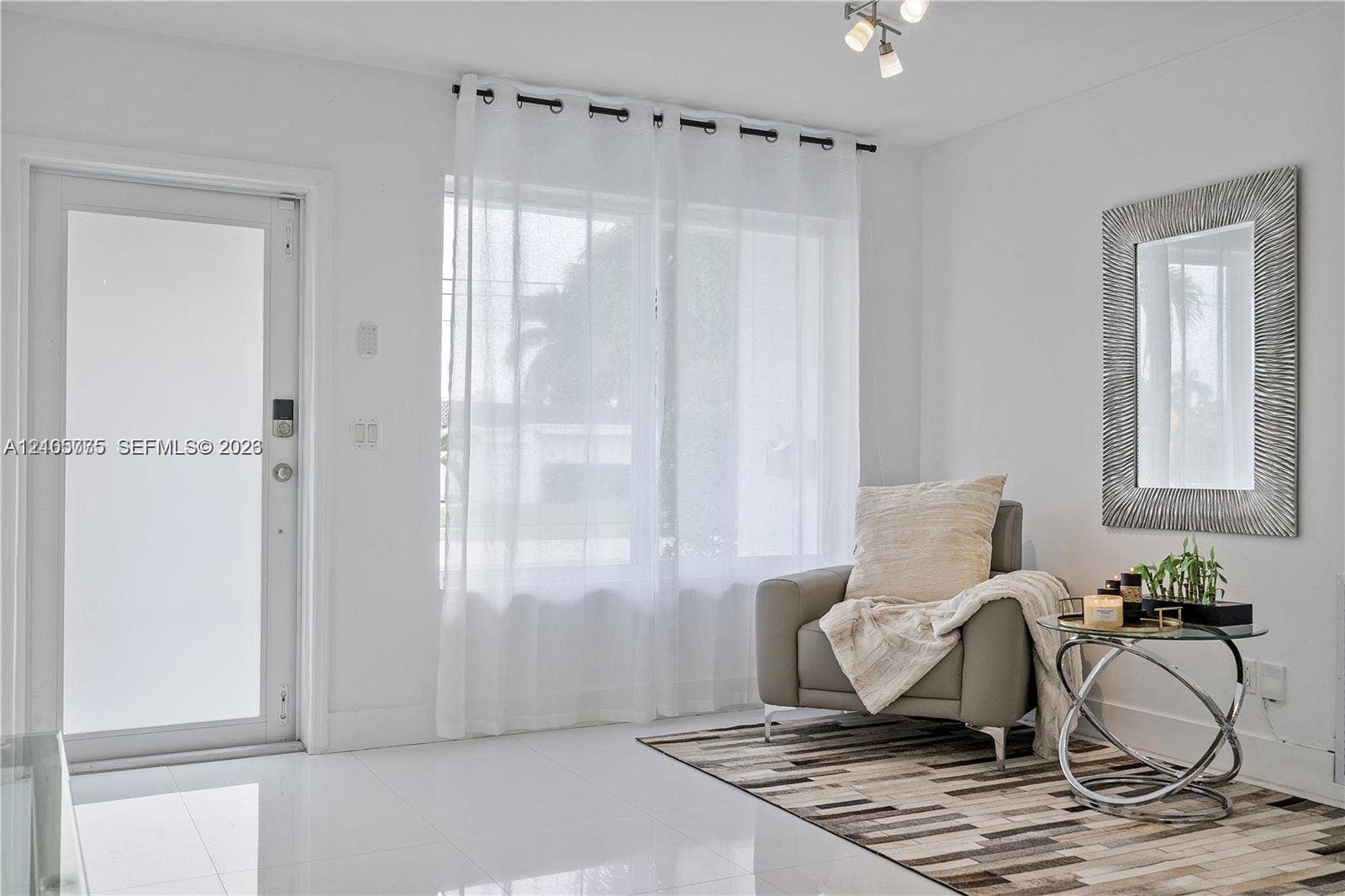 21230 NE 24th Court, Miami, FL 33180 Entryway featuring high-gloss tile flooring, a glass-panel exterior door, a multi-light ceiling fixture, and a large window