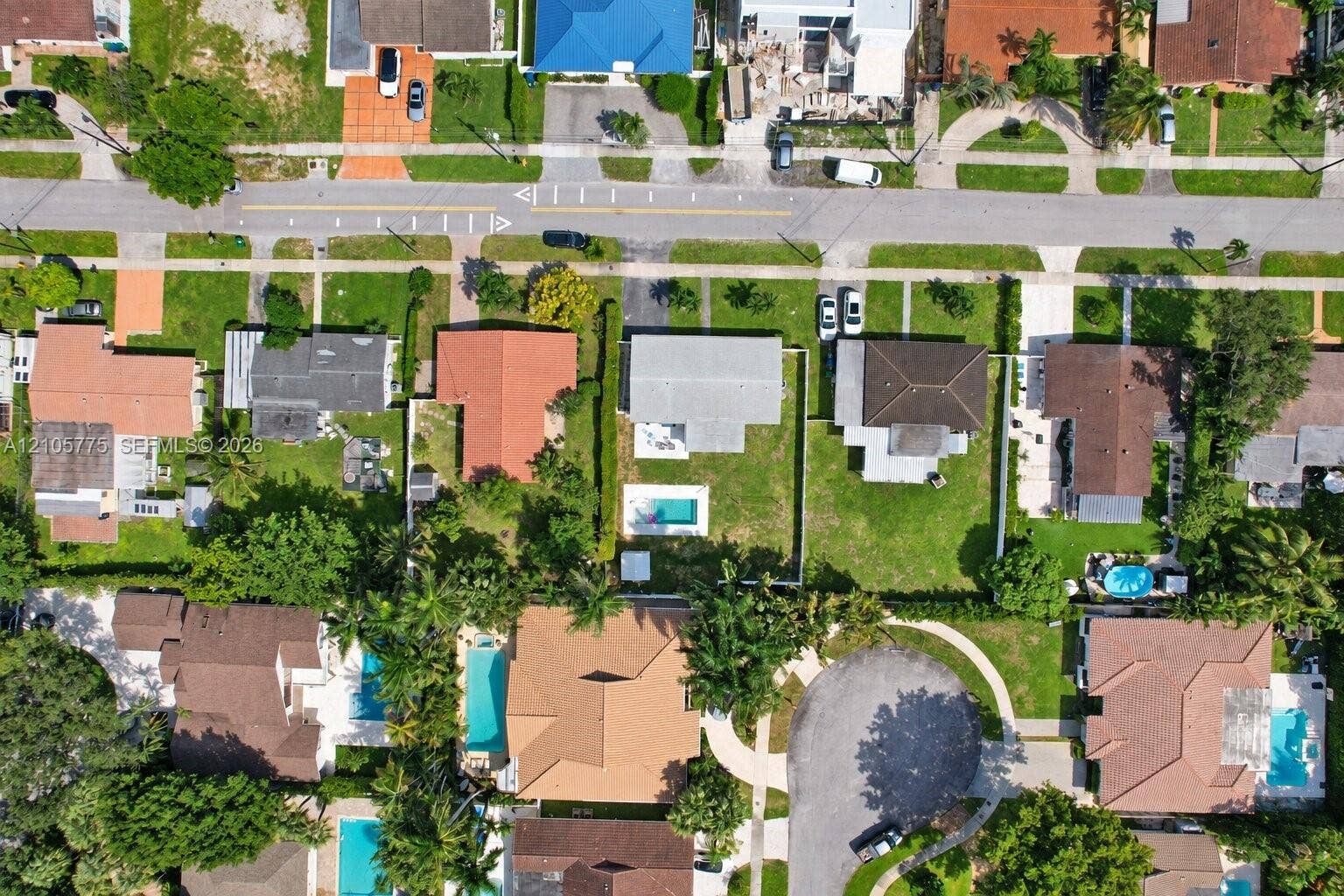21230 NE 24th Court, Miami, FL 33180 Aerial perspective of a single-family property featuring a rectangular in-ground swimming pool, a fully fenced backyard, and a concrete driveway