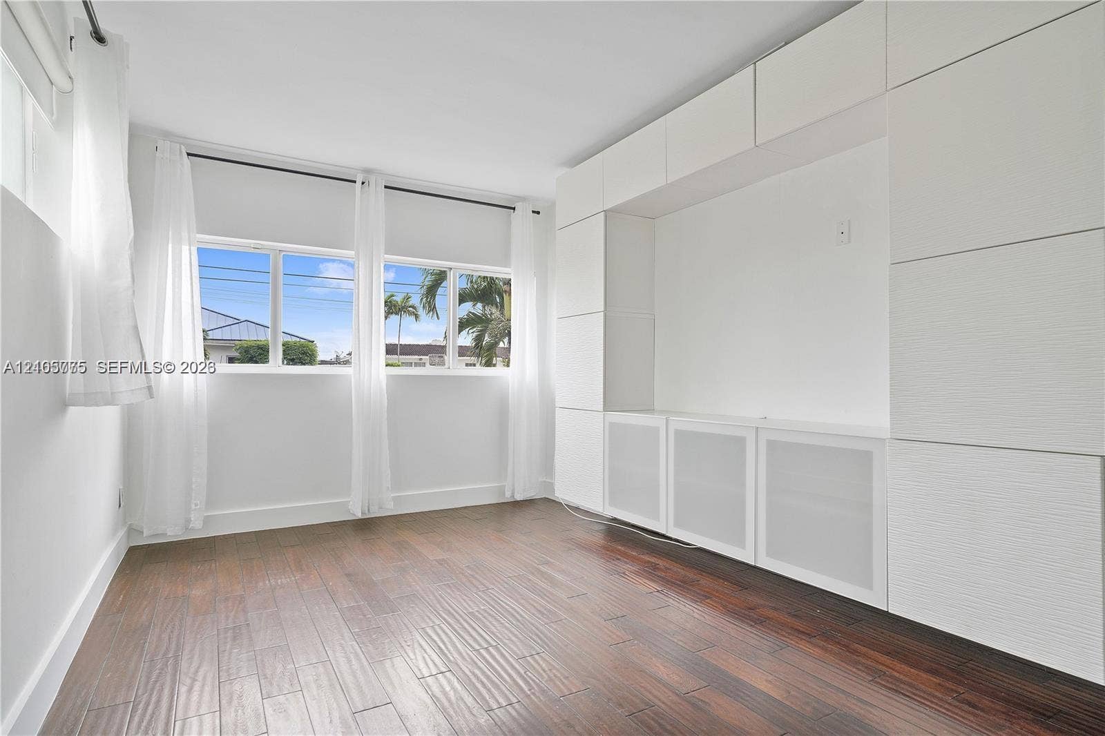 21230 NE 24th Court, Miami, FL 33180 Room with wood-finish flooring, extensive floor-to-ceiling built-in cabinetry, and large windows